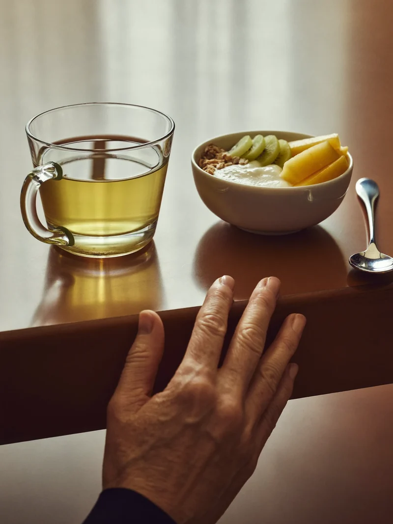 Colazione con tisana, yogurt, avena e frutta in luce mattutina